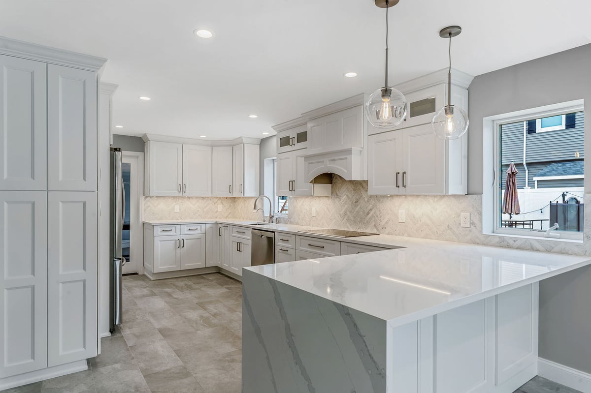 Massapequa kitchen remodel by Kuhn Construction showcasing white cabinets and contemporary lighting