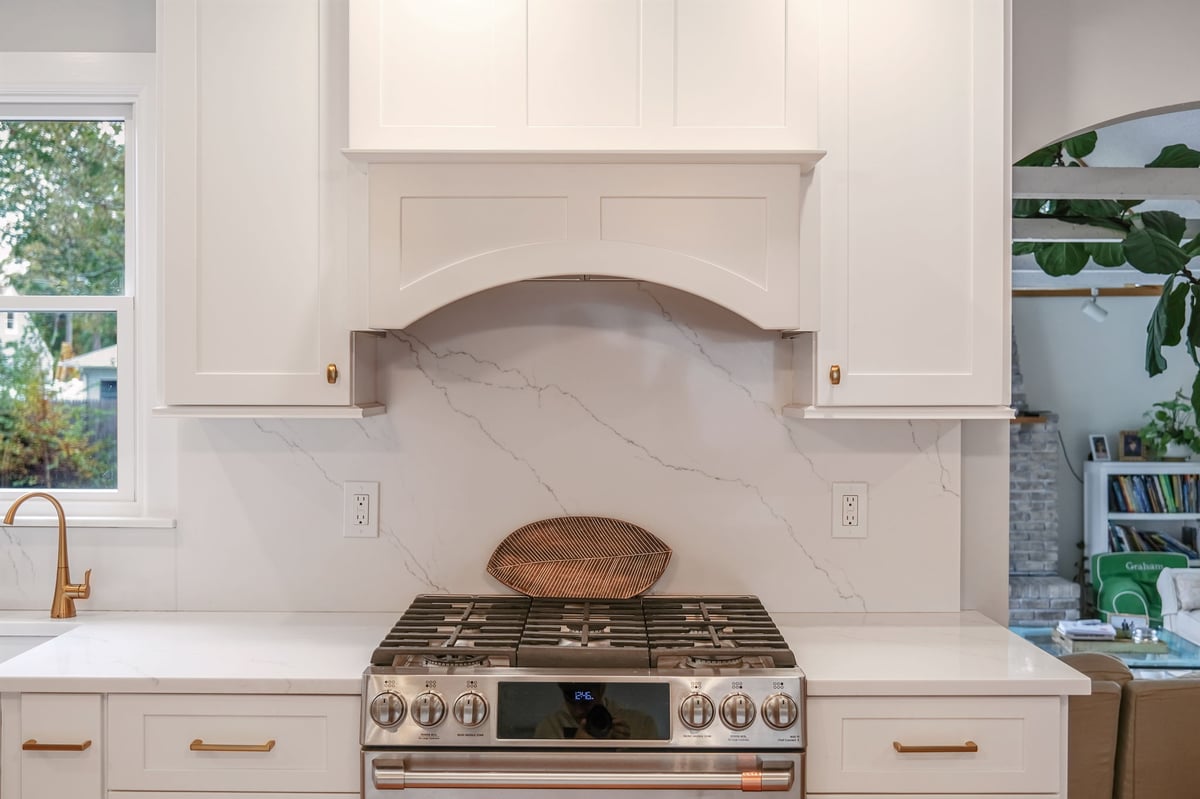 High-end gas stove with white hood in Islip, New York kitchen remodel by Kuhn Construction