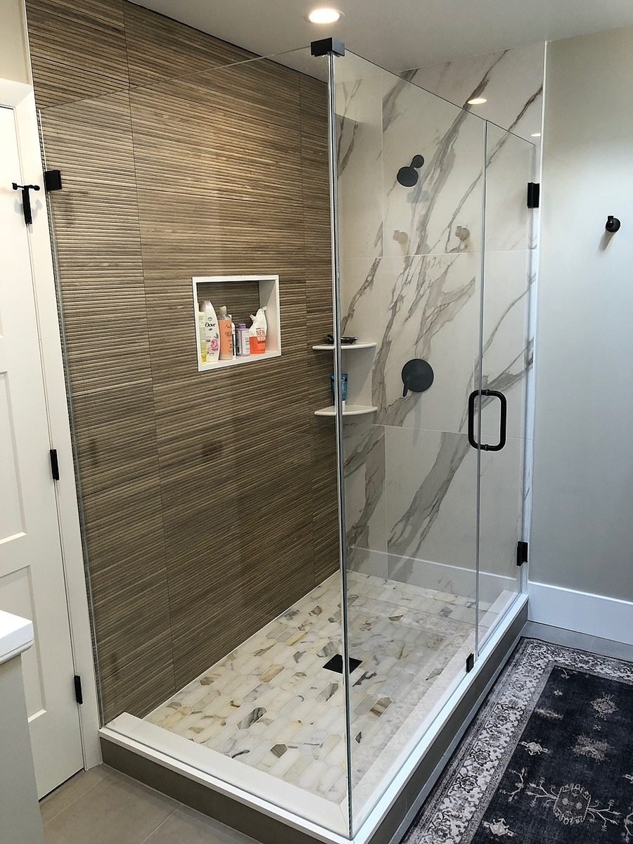 Walk-in shower with built-in wall and corner shelving by Kuhn Construction